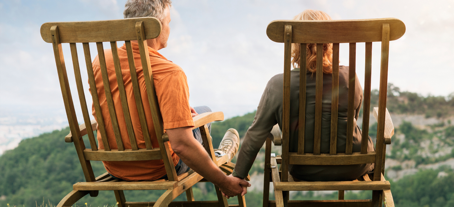A caregiver for someone in chronic pain and their loved one sitting in rocking chairs.
