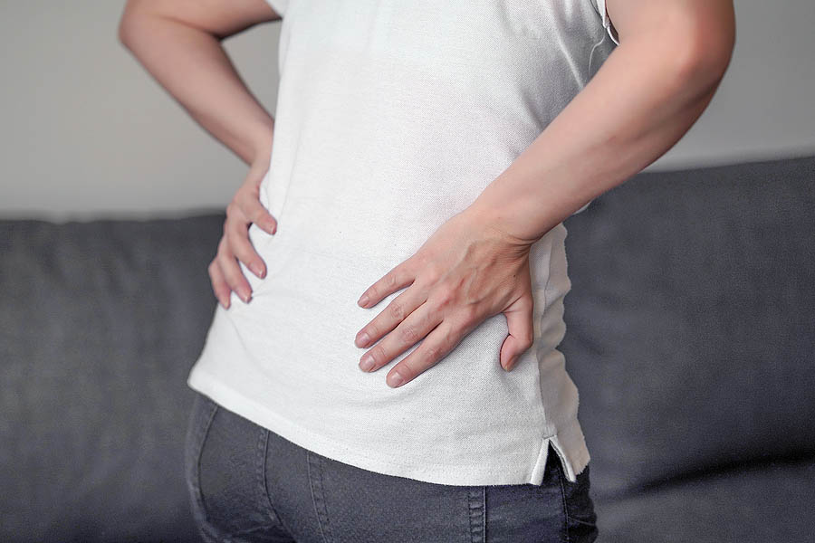 A woman suffering from low back pain, a common cause of degenerative disc disease.